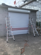 大連喜科門業(yè)有限公司為瓦房店市東港村溫室大棚碰頭房安裝77式電動(dòng)保溫卷簾門的安裝案例