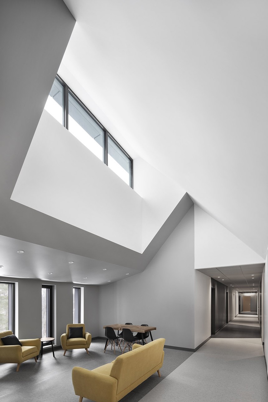 ▼宿舍部分的社交空间,设有高侧窗采光▼宿舍部分的走廊及其共享阅读