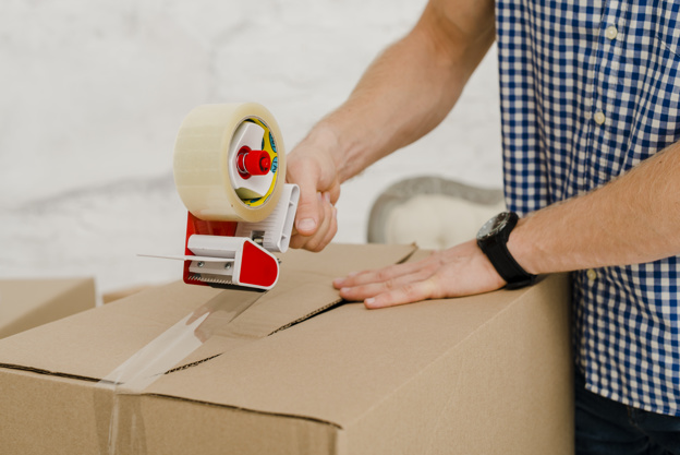 crop-man-packing-box-with-sticky-tape_23-2147758726.jpg