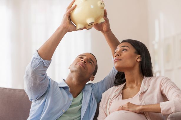 Young-parents-to-be-holding-piggy-bank-holding-piggy-bank-upside-down.jpg