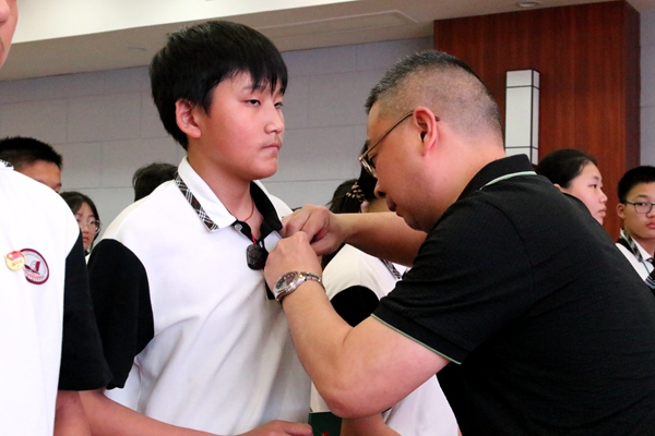 1683462318498114.jpg 为新团员佩戴团徽.JPG