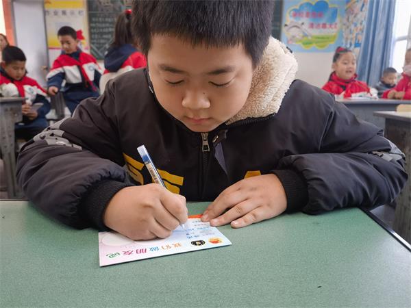 1705882530172733.jpg 图四:认真写交友卡的小朋友.jpg
