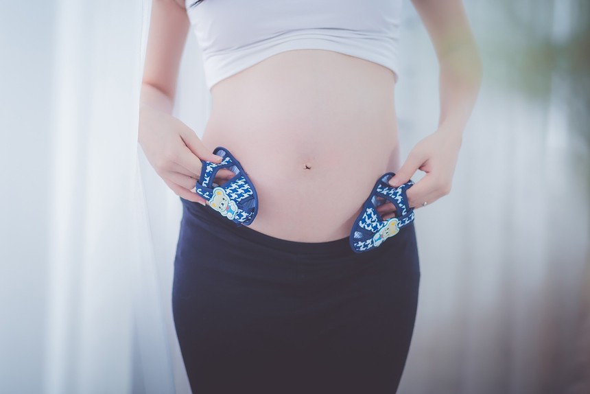 pregnant-woman-holding-baby-shoes-in-her-tummy-157925.jpg