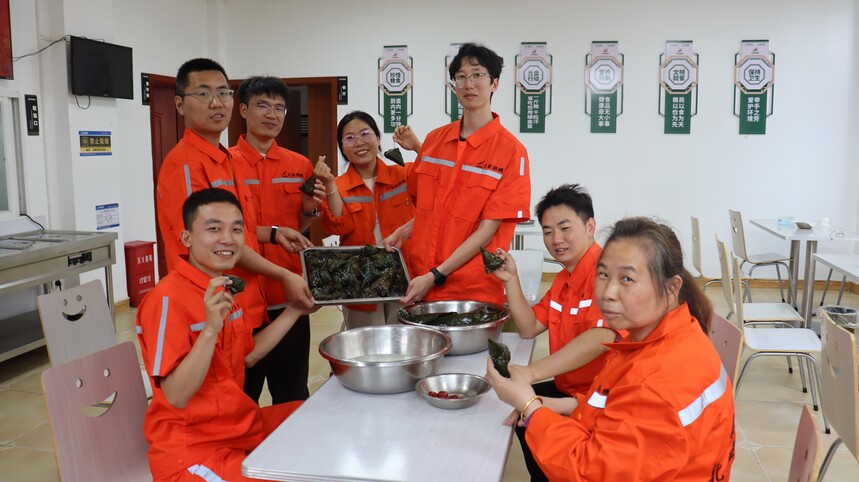 1782703475148954.jpg 4.图为北新路桥集团北新融建公司云南长龙高速公路项目总承包部职工正在展示自己包好的粽子(晏泰杰 摄).JPG