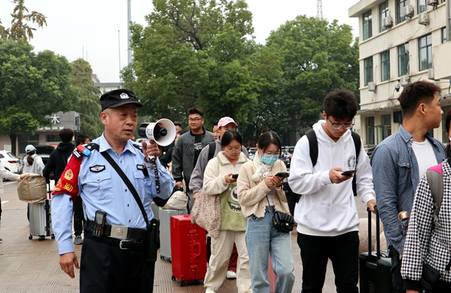 1728474476249032.jpg 民警在新沂站疏导旅客(朱革宇摄影)_proc_副本.jpg