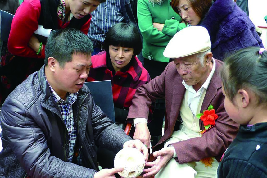 牙雕大师陈忠向尹老介绍多层牙雕.jpg