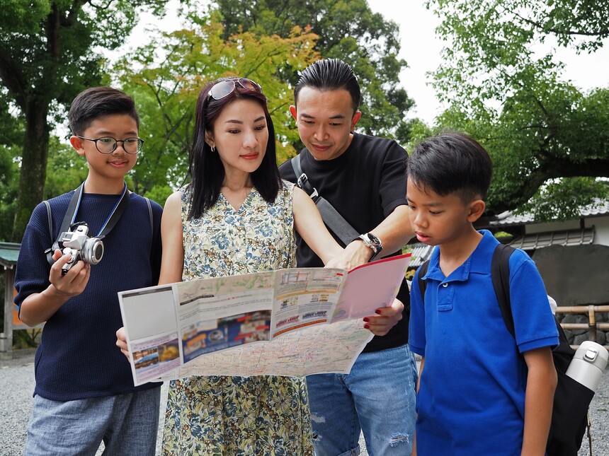 Asian family looking at the map. A mother holding a map while father pointing at the location with .jpg