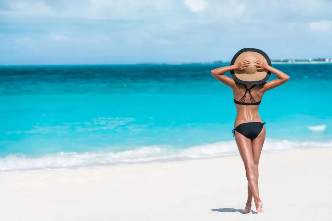 Summer-vacation-happiness-carefree-joyful-woman-standing-on-white-sand-enjoying-tropical-beach-destination.webp.jpg