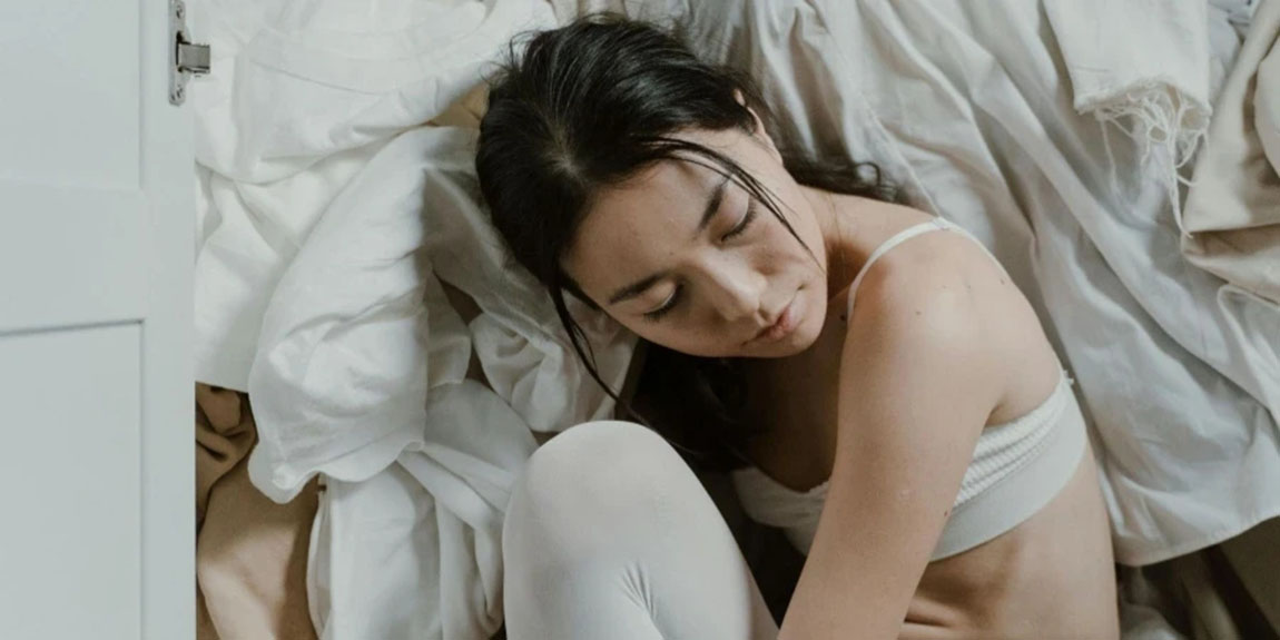 Woman-Sitting-beside-a-Pile-of-Clothes.webp.jpg