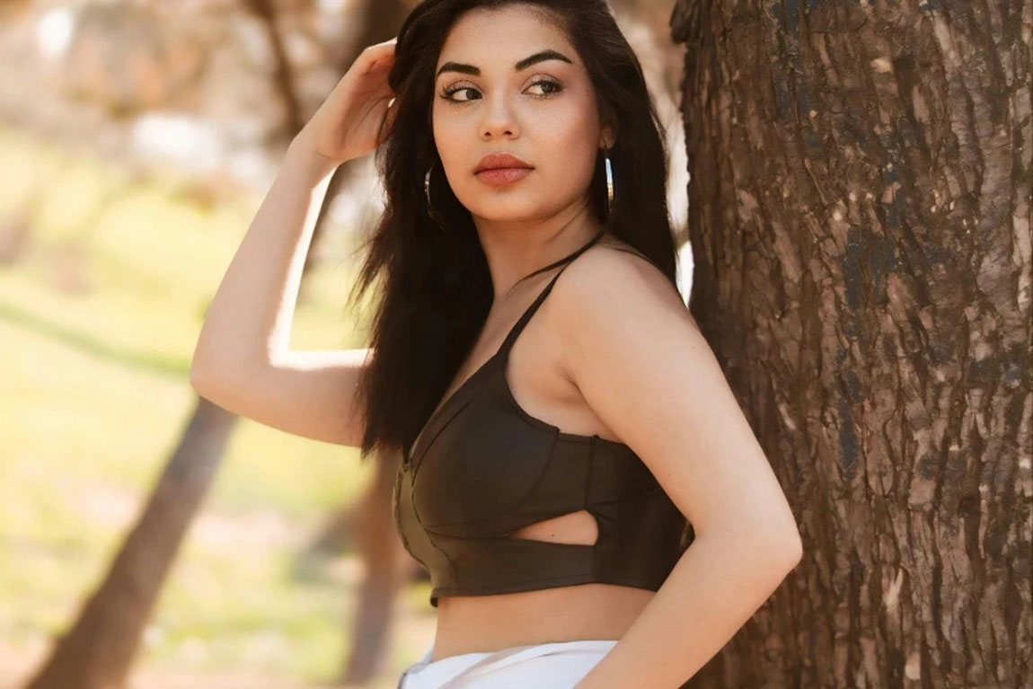 A-woman-in-a-crop-top-and-pants-leaning-against-a-tree-by-Murat-ISIK.webp.jpg
