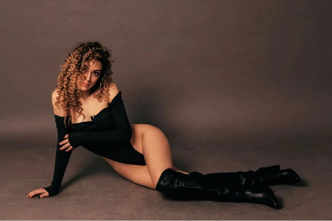 sexy-woman-in-a-black-off-shoulder-bodysuit-and-black-boots.webp.jpg