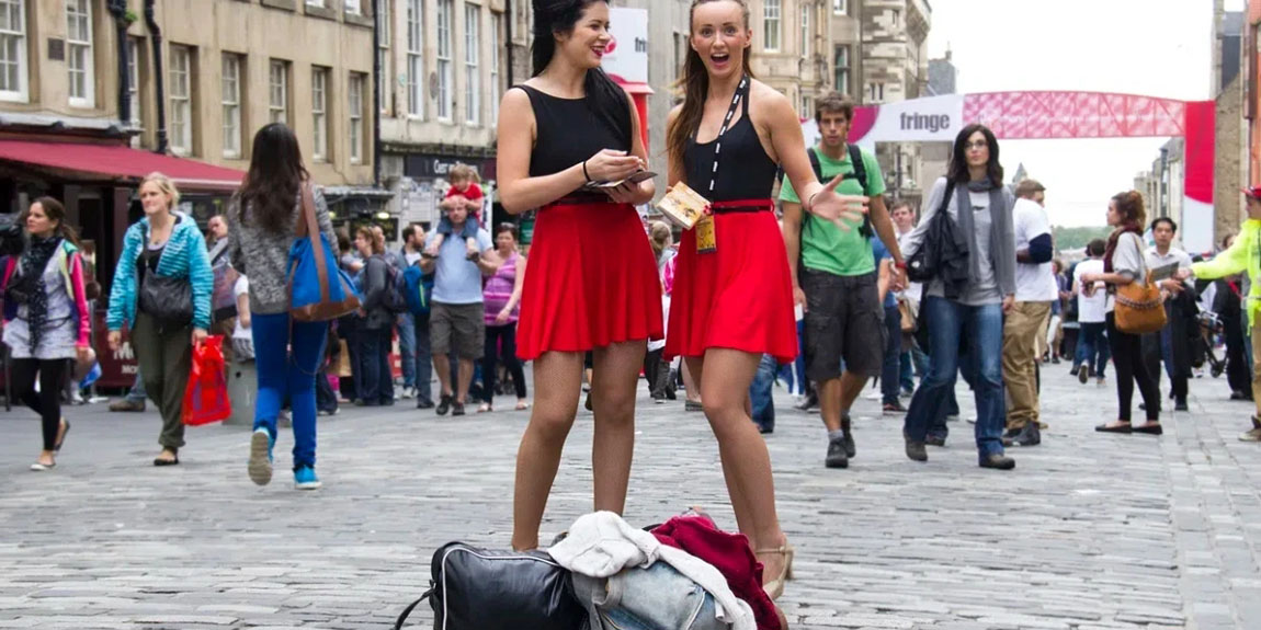 Two-unidentified-girls-hand-out-flyers-on-the-street-at-the-Edinburgh-Festival-Fringe.webp.jpg