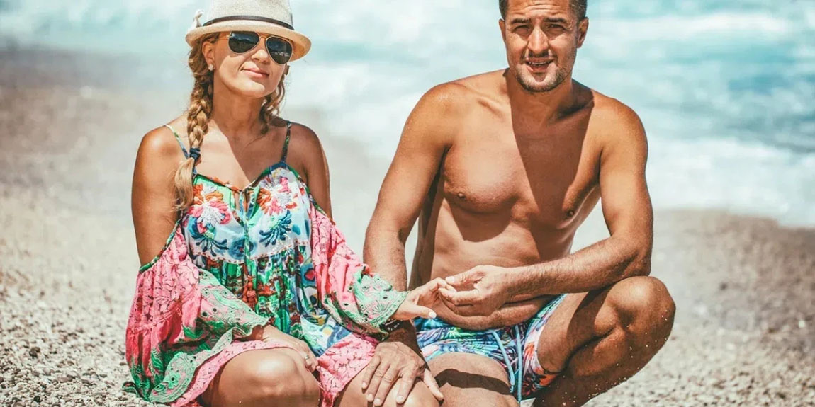 Young-man-and-woman-are-posing-on-the-sea-beach-in-summer-day-and-looking-at-camera-1.webp.jpg