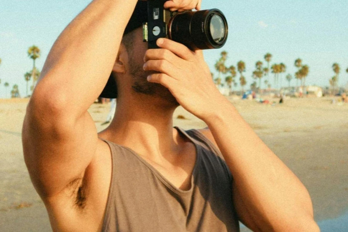 Man-Using-Dslr-Camera-While-Standing-on-Seashore.webp.jpg