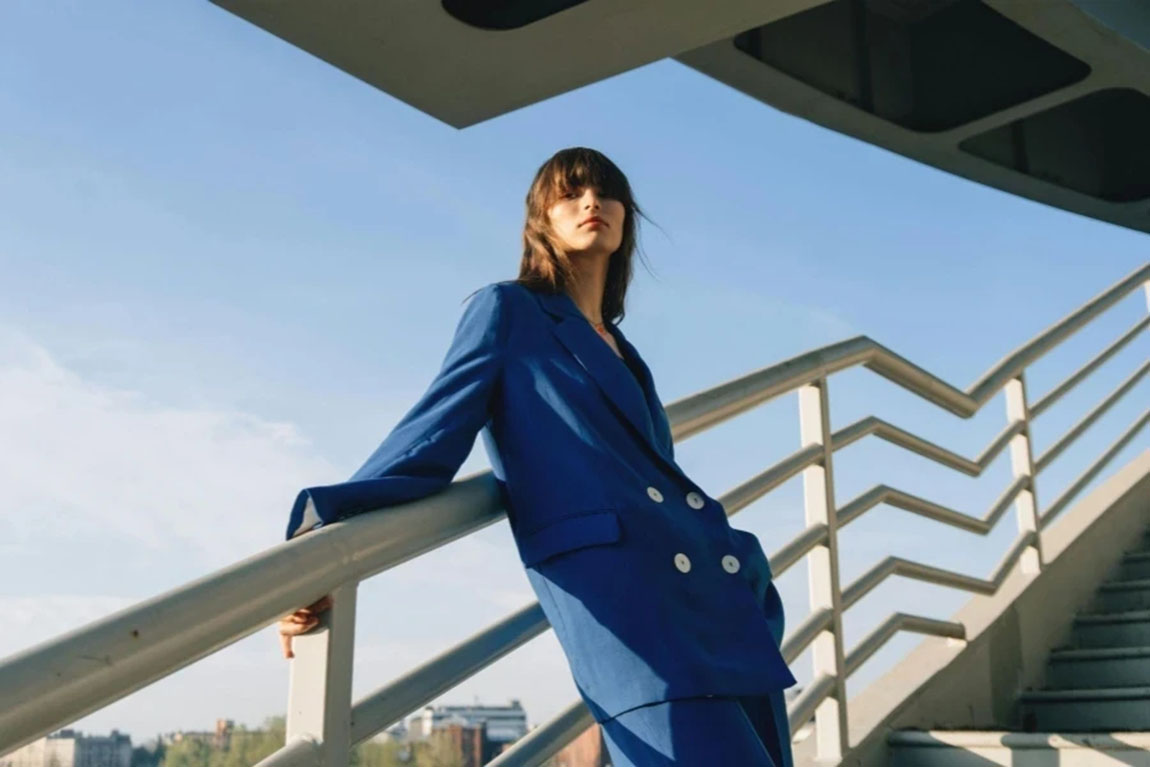 Woman-in-Blue-Clothes-Leaning-on-Metal-Railing.webp.jpg
