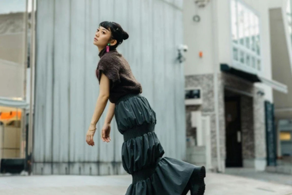 Young-Woman-in-a-Midi-Skirt-Standing-on-One-Leg.webp.jpg