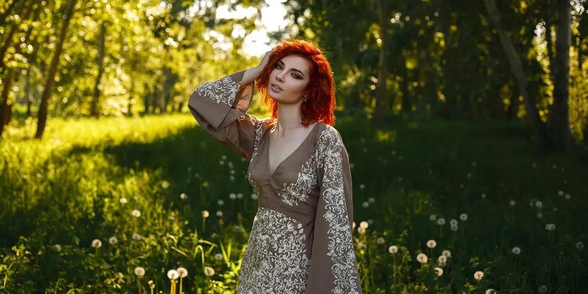 Stylish-woman-in-embroidered-dress-stands-in-sunlit-summer-forest-by-Ivan-Babydov.webp.jpg