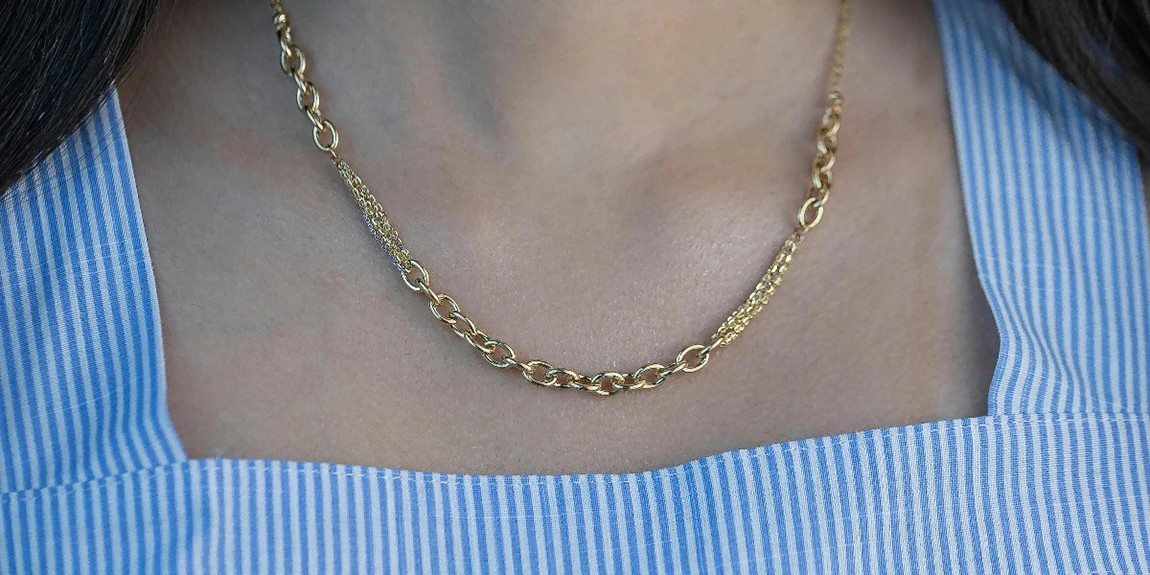Close-up-of-a-woman-wearing-a-delicate-gold-necklace-with-a-striped-top-by-Maryam.webp.jpg