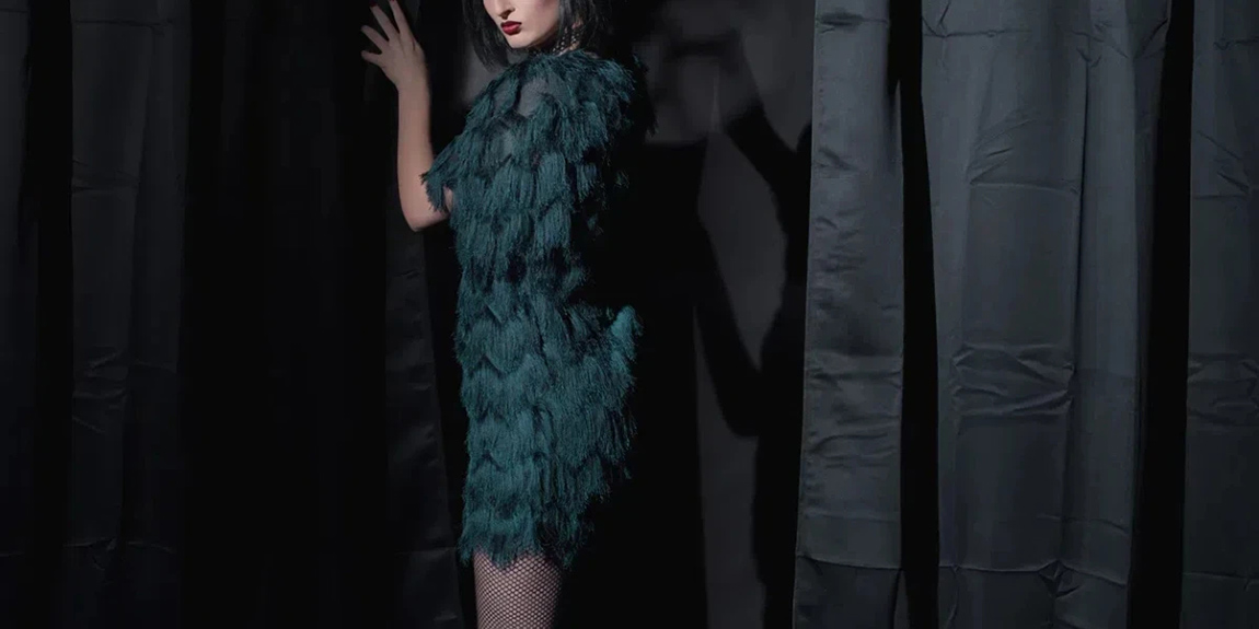 Dark-witch-fashion-woman-holding-curtain.webp.jpg