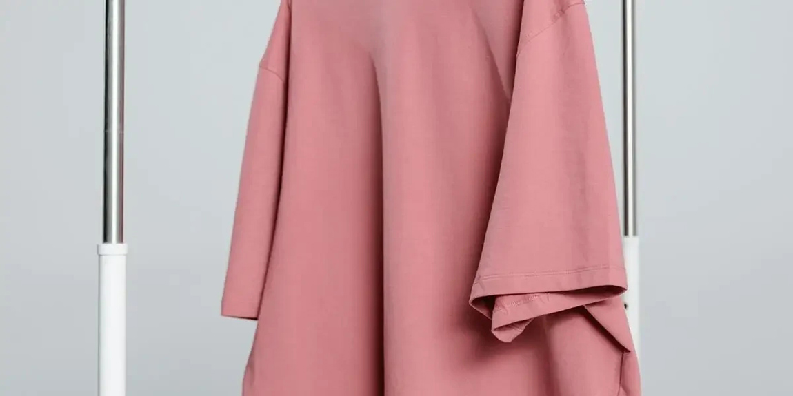 A-minimalist-pink-unisex-t-shirt-hanging-on-a-white-rack-against-a-light-background-by-MART-PRODUCTION.webp.jpg