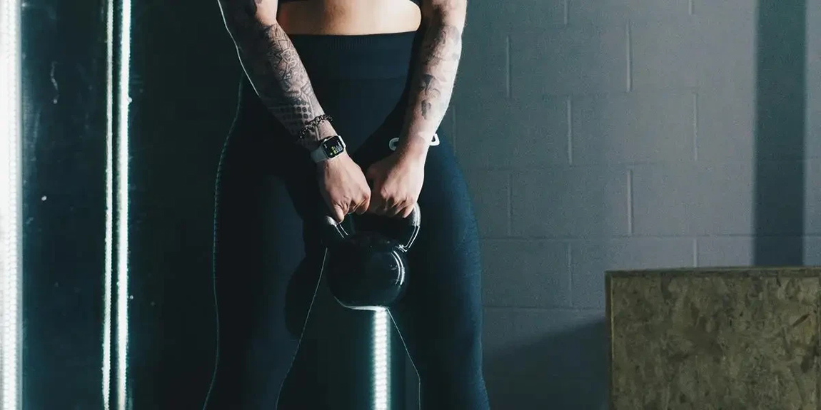 a-woman-with-tattoos-holding-a-kettle-in-a-gym-by-Ambitious-Studio-Rick-Barrett-1.webp.jpg