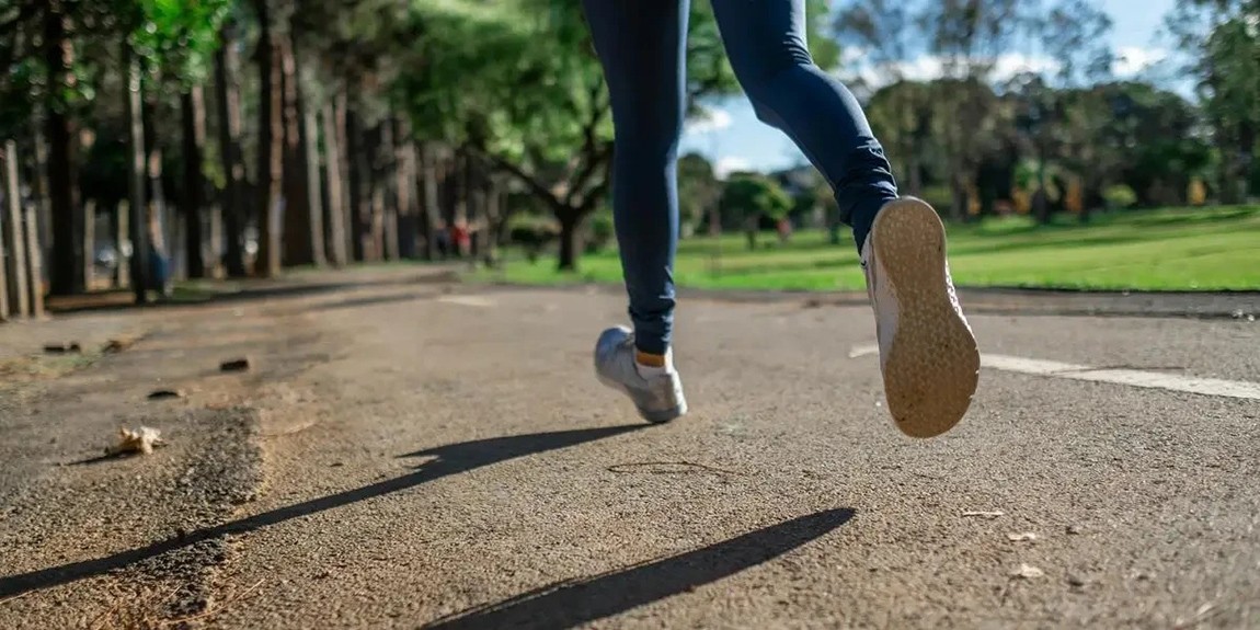 A-woman-running-outdoors-on-a-sunny-day-along-a-scenic-park-trail-focusing-on-fitness-and-health-by-Daniel-Reche.webp.jpg