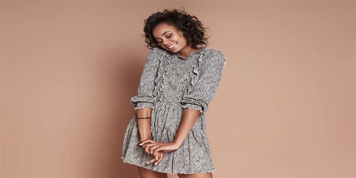 Beautiful-young-African-woman-smiling-while-standing-against-brown-background.webp.jpg