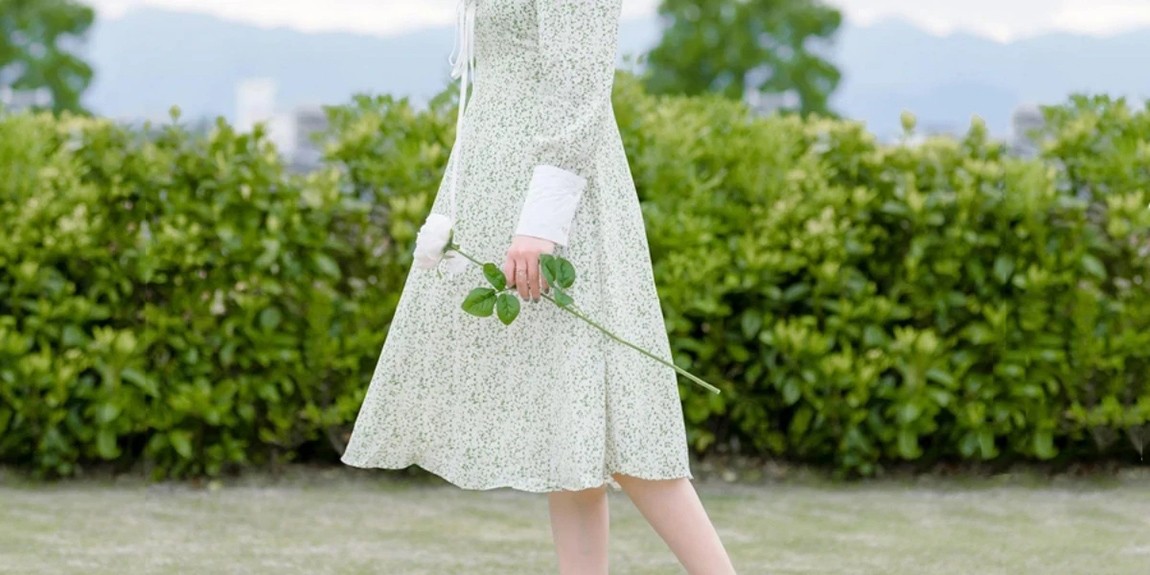 Lady-on-floral-white-and-green-gown-holding-a-flower.webp.jpg