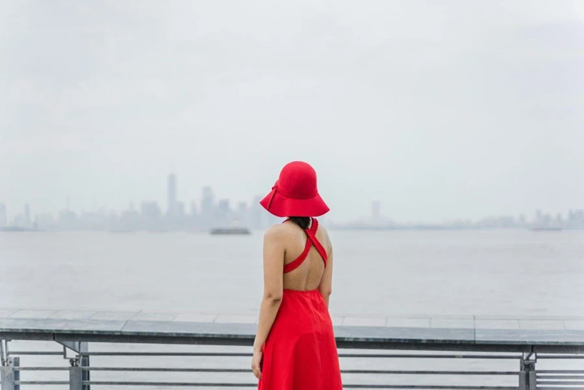 A-woman-wearing-a-red-gown-and-hat.webp.jpg