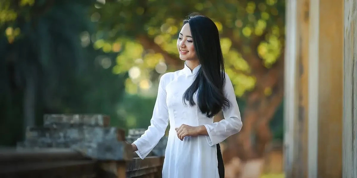 A-woman-dressed-in-a-white-garment-stands-barefoot-on-dry-sandy-grass-creating-a-whimsical-outdoor-scene.webp.jpg