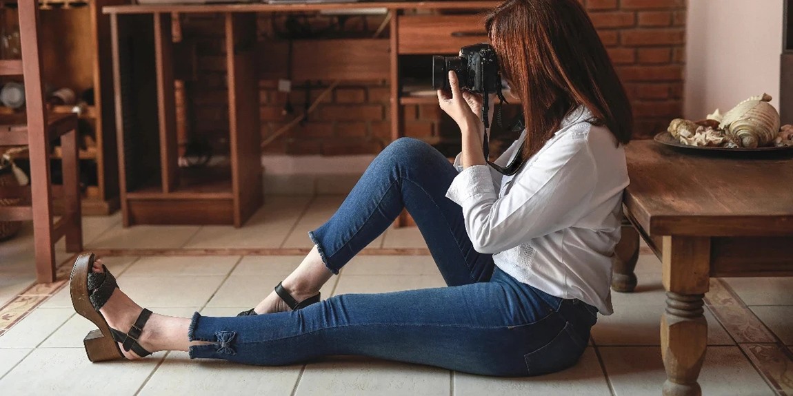 Photographer-Sits-On-Floor-Holding-A-Camera-To-Their-Face.webp.jpg
