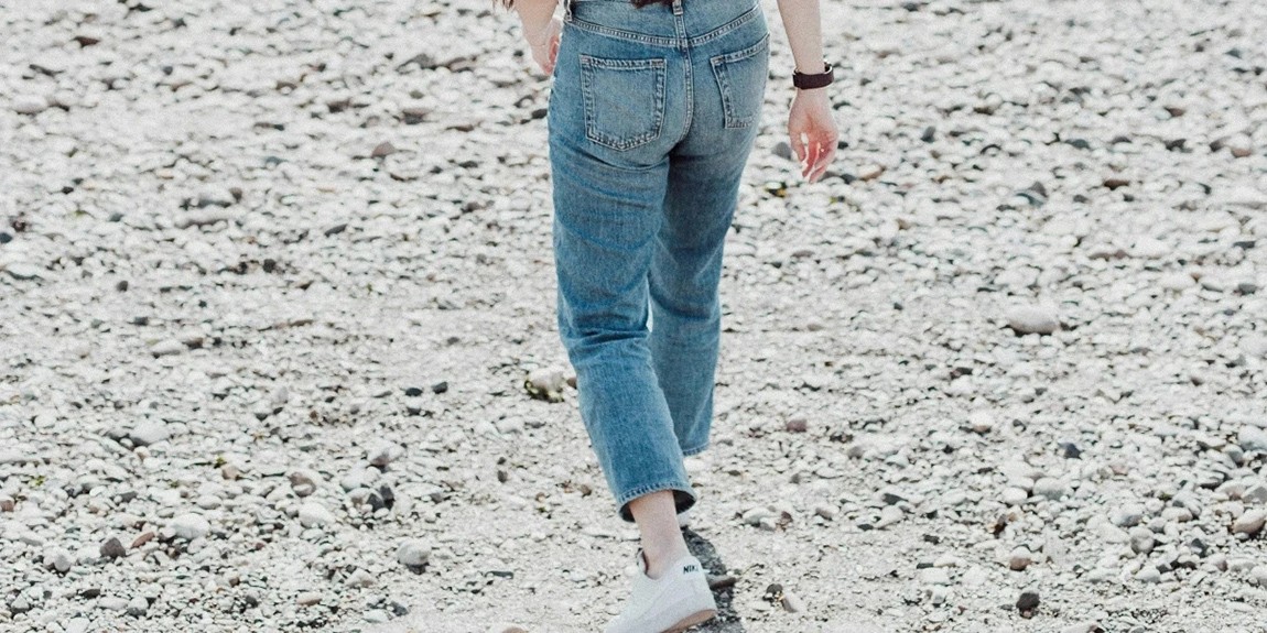 a-woman-walking-across-a-sandy-beach-next-to-the-ocean-by-Priscilla-Du-Preez-🇨🇦.webp.jpg