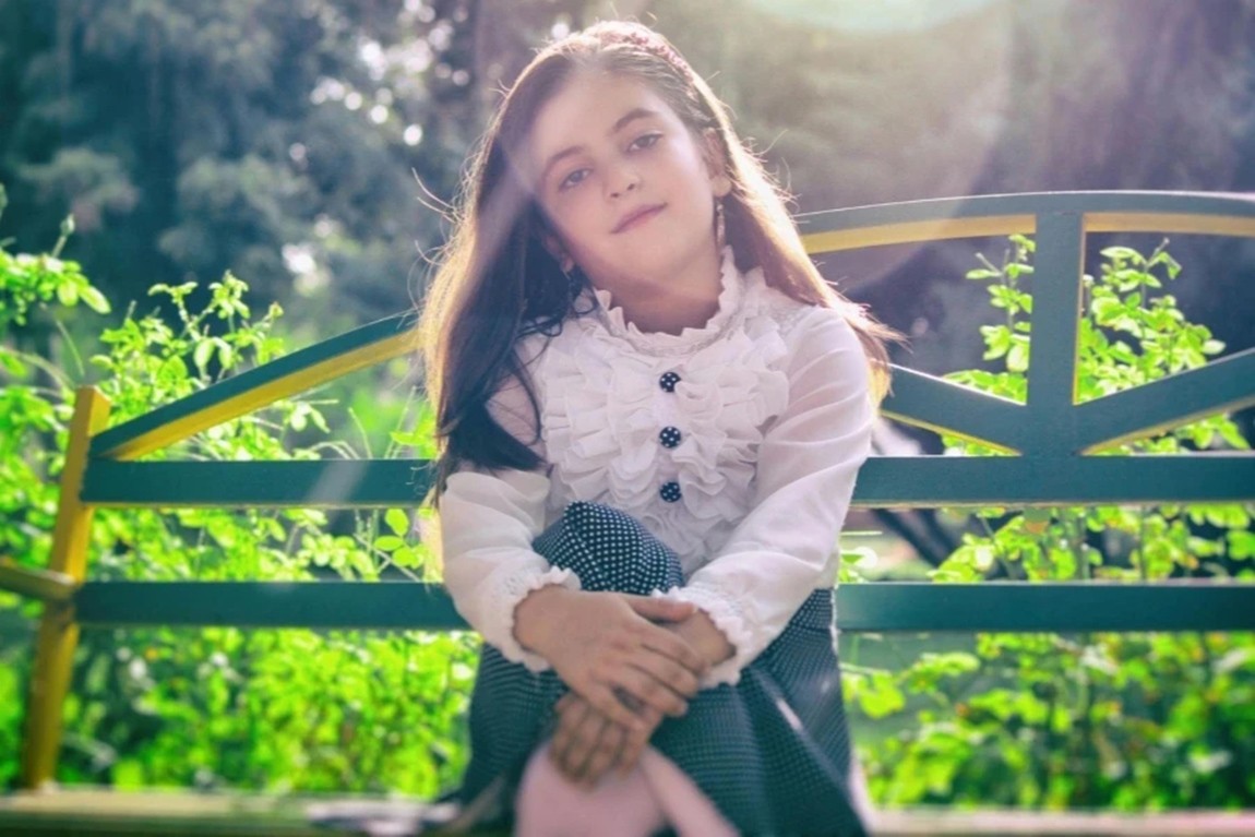 Girl-Sitting-on-Bench-Near-Plants.webp.jpg