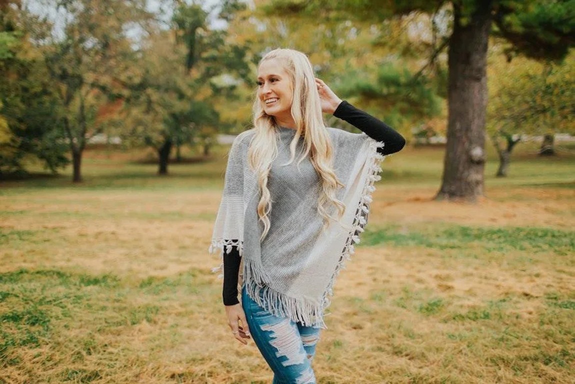 a-smiling-blonde-lady-rocking-a-grey-poncho.webp.jpg