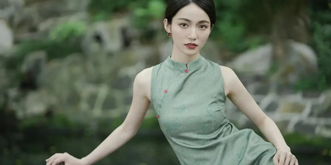 Portrait-of-a-young-woman-wearing-a-green-traditional-dress-posing-elegantly-outdoors-in-a-garden-by-Venus-Xu.webp.jpg
