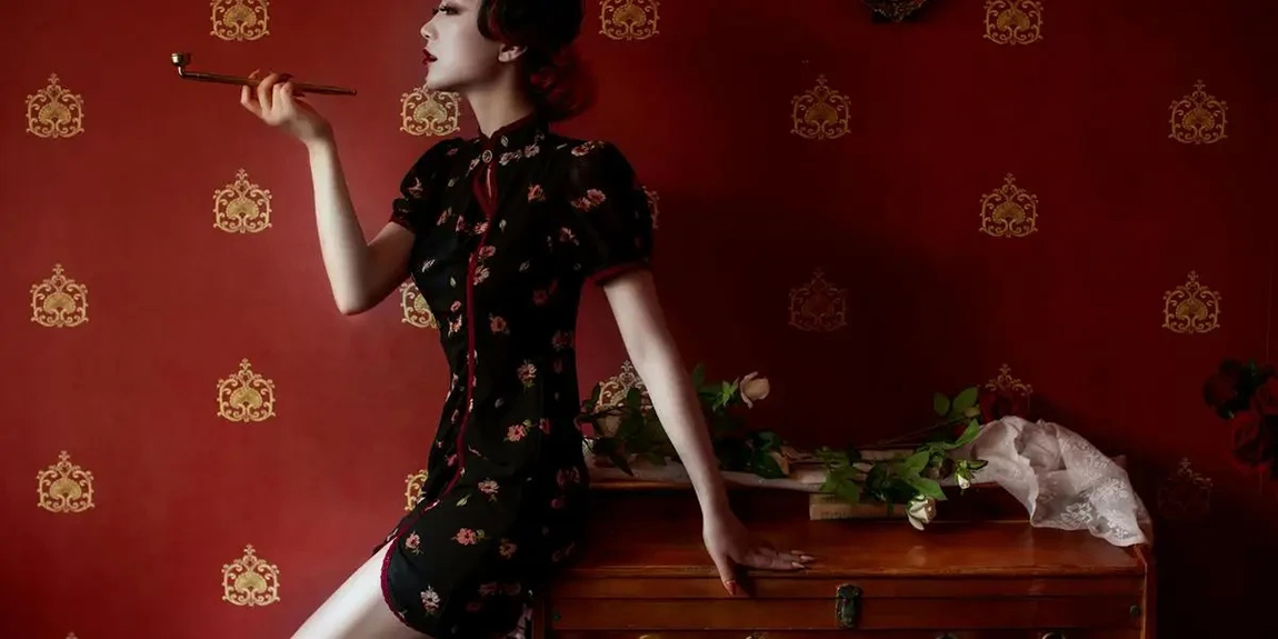 Elegant-woman-in-cheongsam-dress-holding-cigarette-holder-against-a-classic-red-wallpaper-background-by-YI-REN.webp.jpg