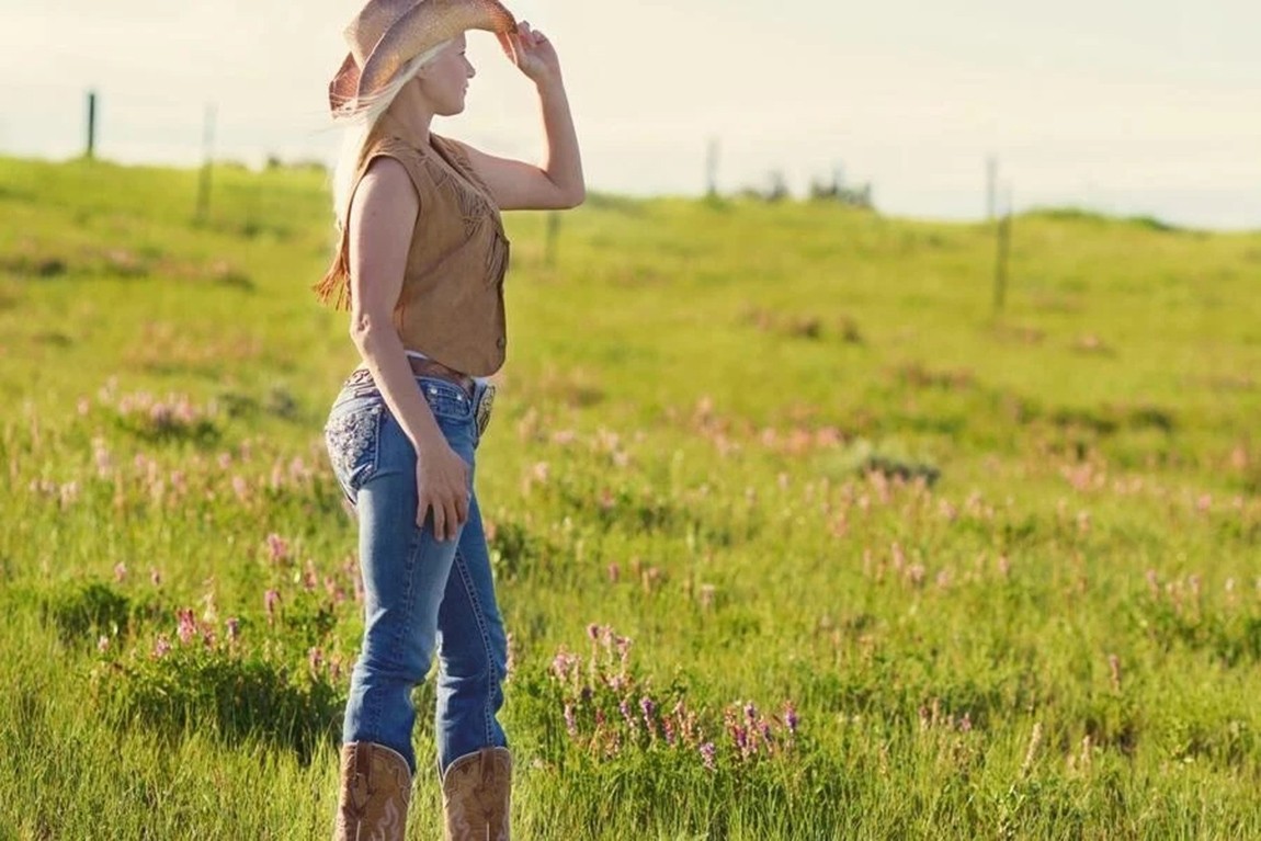 Woman-wearing-brown-cowboy-boots-vest-and-hat.webp.jpg