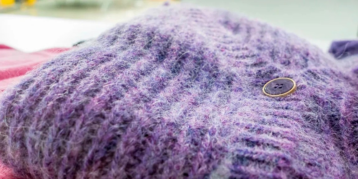 Close-up-of-strains-of-fabric-fibers-and-a-button-on-a-winter-garment.webp.jpg