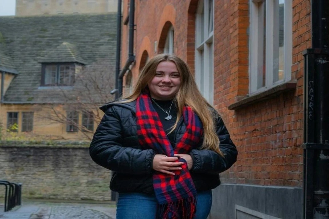 A-woman-in-a-black-jacket-and-patterned-scarf.webp.jpg