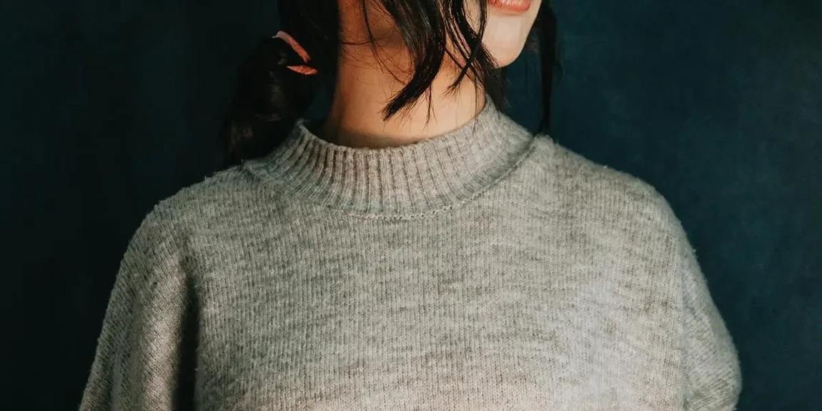 Persons-Torso-And-Neck-In-A-Grey-Sweater.webp.jpg