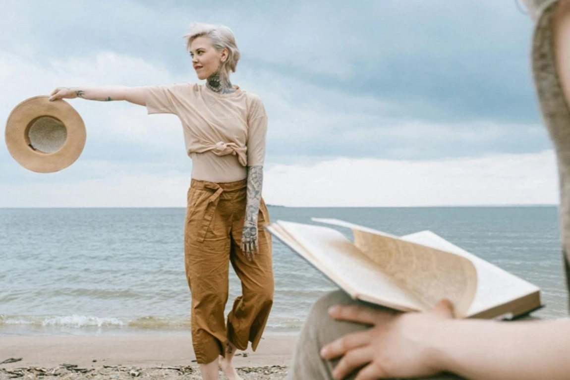 Woman-Holding-Hat-on-Beach.webp.jpg